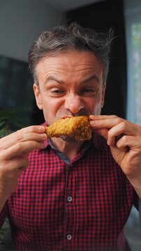 Junk food advertisement concept. Man eating fried chicken, enjoying fast food.