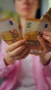 Woman counting euro bills, close-up. Vertical