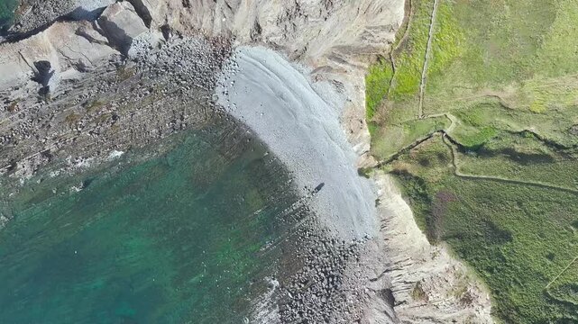 Top Down view of Cliffs and Farms over North Devon and Cornwall Coastpath Border from a drone, Welcombe Mouth Beach, Devon, Cornwall, England, Summer 2026