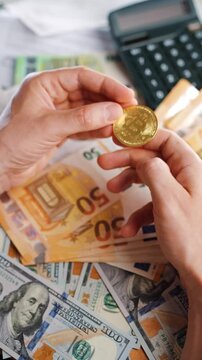 Hands toss and rotate BTC bitcoin against the dollars and euros