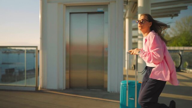Caucasian woman pulling a suitcase and running, late for flight. 