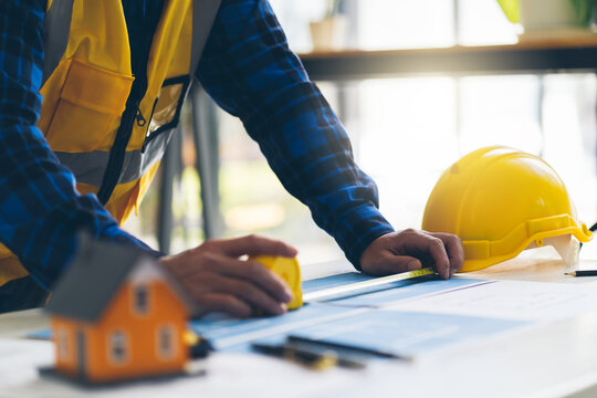 Architect or engineer working in office with blueprints,engineer inspection in workplace for architectural plan,sketching a construction project ,Business construction concept.
