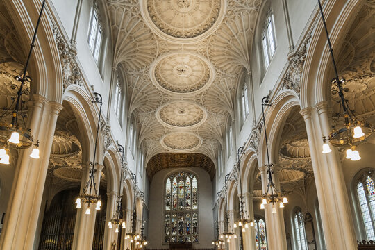View of the ornate vaulted ceiling and chandeliers inside a historic church in London, England, United Kingdom.