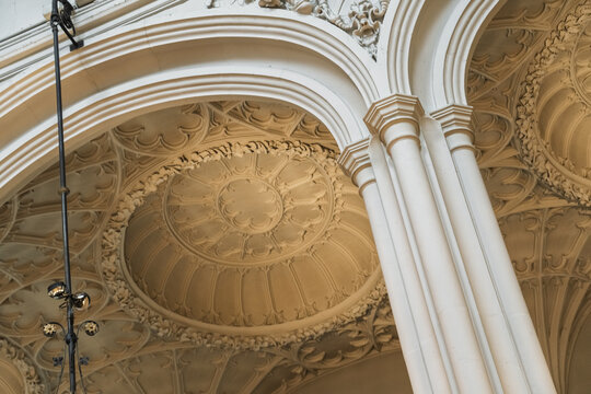 View of the intricate gothic vaulted ceiling with ornate stone carvings and elegant columns in a historic building in London, England, United Kingdom.
