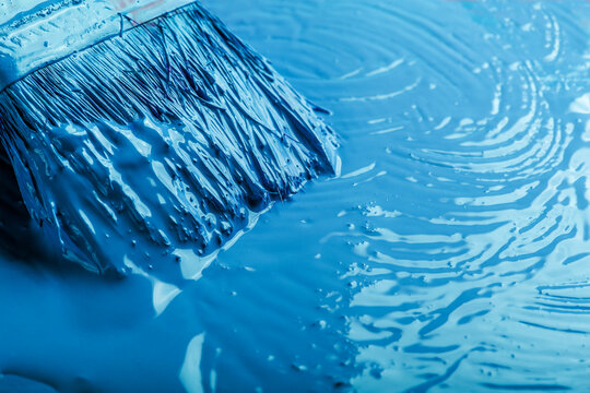 a brush with blue paint on a blue background