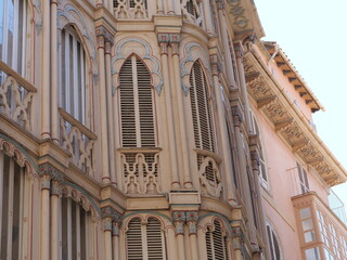 Elegant Neo-Mudejar Building Facade with Curved Bay Windows and Shutters © Ena