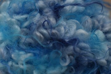 Extreme macro close-up of soft and fluffy blue curly yarn texture © Luciana