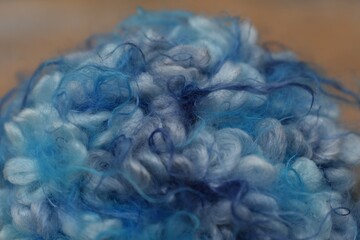 Extreme macro close-up of soft and fluffy blue curly yarn texture © Luciana
