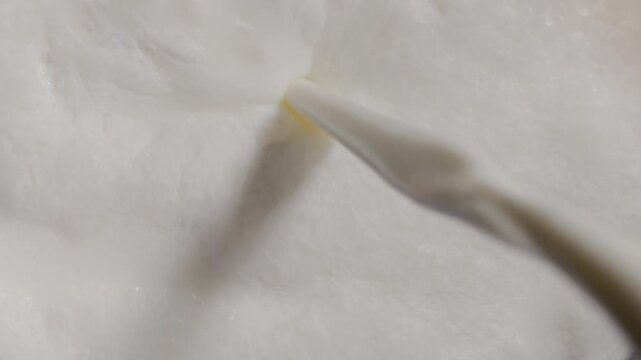 pouring milk into a glass of milk, close up macro 