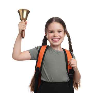 Smiling little girl with backpack ringing school bell on white background
