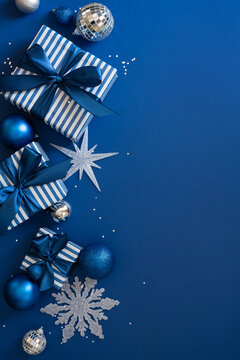 Blue Christmas gift vertical composition with ribbons, ornaments and decorations for Merry Christmas and Happy New Year on night background
