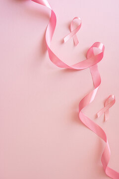Breast cancer awareness month pink ribbon on soft vertical pink background for health campaign and support