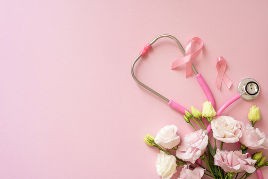 Breast cancer awareness month stethoscope and pink ribbon on soft pink background with delicate flowers
