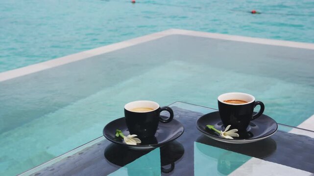 Luxury coffee travel experience. Coffee in espresso cups for two people on luxury pool side on vacation.