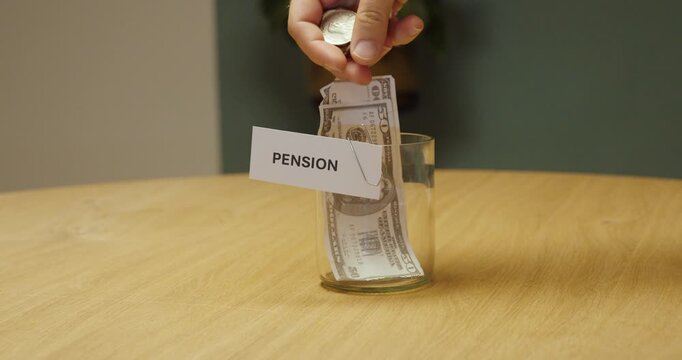 Hand placing cash into a glass jar labeled &ldquo;Pension,&rdquo; representing saving money for retirement, pension planning and long-term financial security.