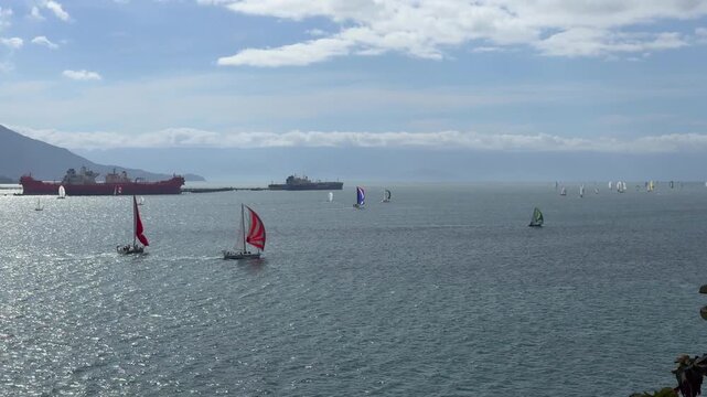 Sailboats Sailing in the Waters of Ilhabela, Brazil, with Mountains and Cargo Ships in the Background