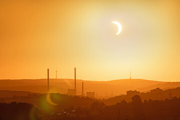 12 August 2026, a partial solar eclipse appears over Altbach power plant chimneys and Stuttgart TV tower, seen from Rosswälden, Germany. © jiriviehmann