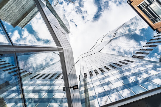 View of modern glass skyscrapers reflecting the blue sky and clouds in London, England, United Kingdom.