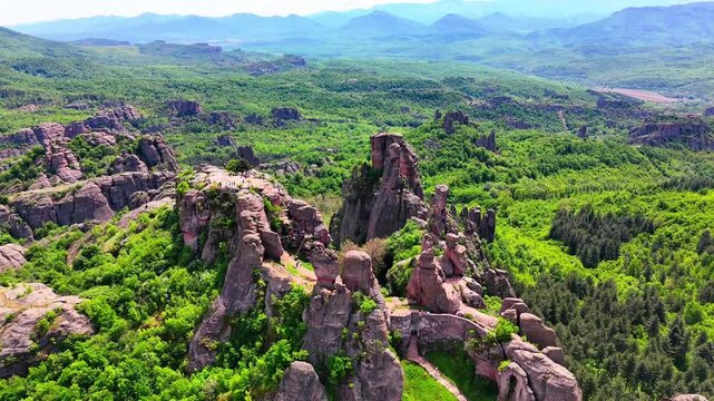 Dramatic Belogradchik Rock Formations Aerial Orbit View with Lush Green Forest in Bulgaria