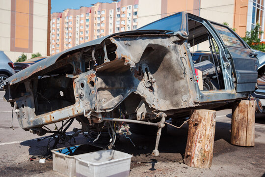 Dismantled car chassis with rusty metal, damaged vehicle parts, automotive repair and salvage.