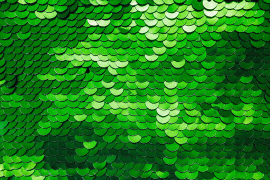 Bright green metallic sequins arranged in a flat overlapping pattern creating a glamorous party background texture