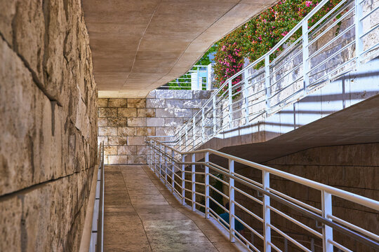 Modern Stone Architecture Walkway with White Railings and Blooming Flowers