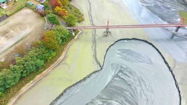 Top Down 4K Drone View of Red Suspension Bridge Over Exposed Dry Lakebed Miwa Lake Japan Autumn