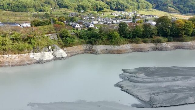 Aerial 4K Drone View of Low Water Exposed Lakebed with White Banks and Village in Japan Autumn