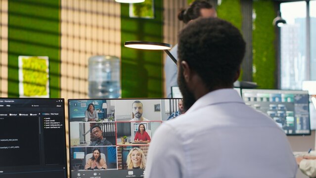 Startup office team collaborates by video call to brainstorm backup solutions against data loss, with remote developers and coworkers discussing AI coding during an online teleconference.