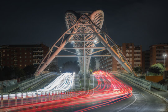 View of the modern Ponte della Musica bridge illuminated at night with long exposure light trails from traffic in Rome, Lazio, Italy.