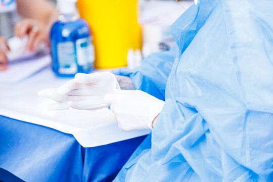 Healthcare worker putting on protective latex gloves before clinical procedure