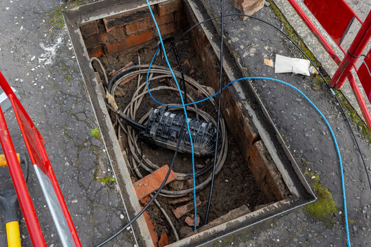 Fibre optic joint closure in open telecoms chamber with draw ropes