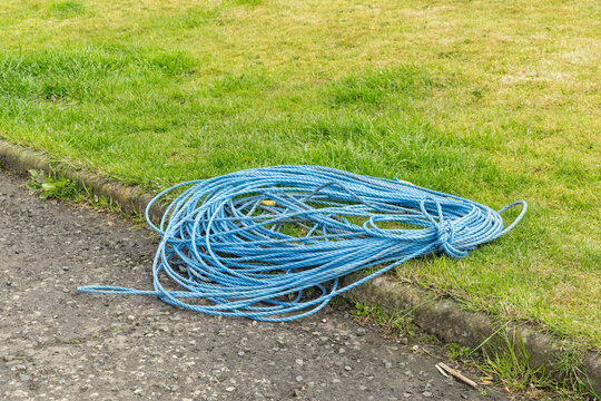 Coil of blue draw rope on grass verge at telecoms street works