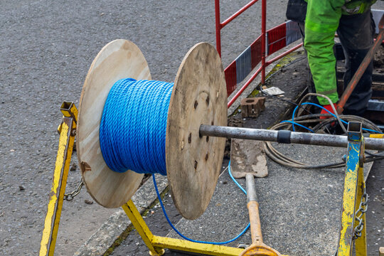 Cable drum of blue draw rope on stand at telecoms street works
