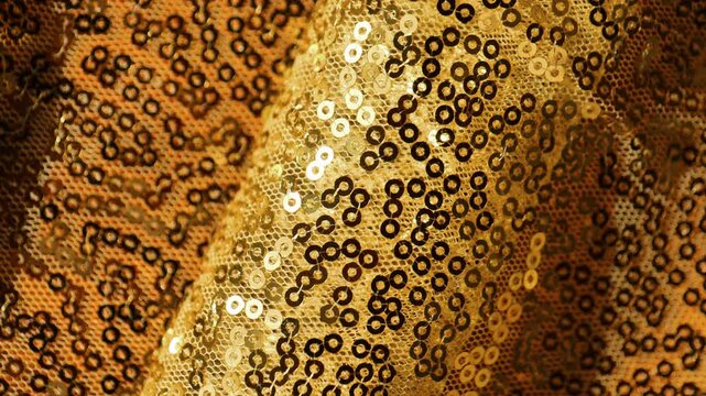 Golden Sequin wallpaper with Folds. golden textile festive background.shiny fabric. 4k footage