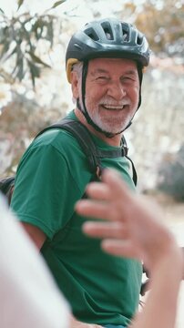 Close-up of a handsome senior cyclist man with a white beard smiling at the camera while enjoying a healthy lifestyle and outdoor sport activity with his electric bike in the park