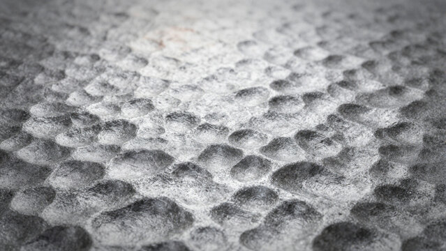 textured metalic surface with a pattern of concave holes