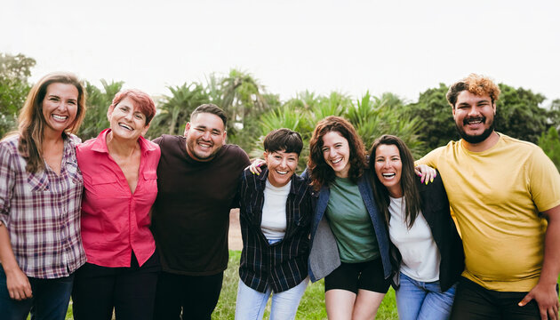 Happy multigenerational people having fun hugging at public park