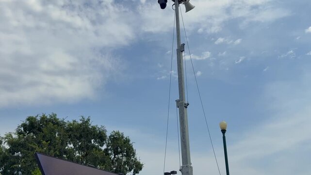 Solar powered mobile security camera trailer with dome cameras, megaphones, solar panels operating in commercial parking lot for crime deterrence
