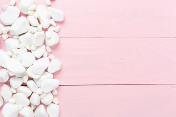 White pebble stones on wooden background, top view © Liami