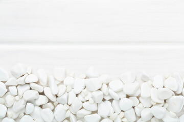 White pebble stones on wooden background, top view © Liami