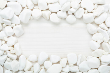 White pebble stones on wooden background, top view © Liami