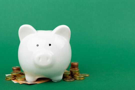 Piggy bank with coins on color background