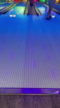 Lanes 6 and 7 at glowing bowling alley with blue neon lighting, representing viral 6-7 internet meme, sports recreation, night bowling fun - six seven