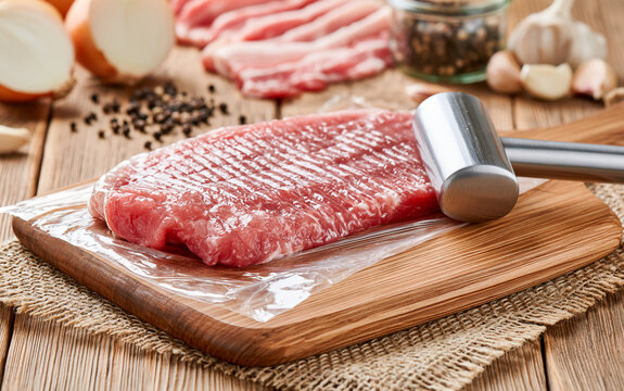 Fresh red meat and a hammer for beating meat
