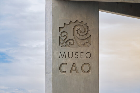 Trujillo, Peru - January 10, 2024: Concrete column with carved Museo Cao logo and text featuring Moche-inspired spiral motifs