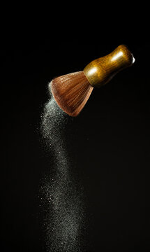 Big Soft Makeup brush with powder explosion. Cosmetic brush splash powder dust with silver glitter sparkling for make up. Black background isolated on photo element