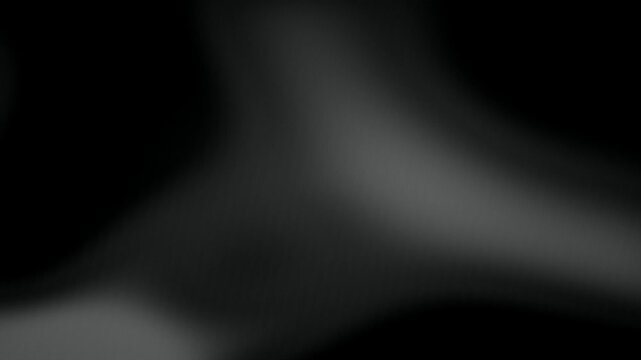 Soft grey light undulates slowly across a dark background