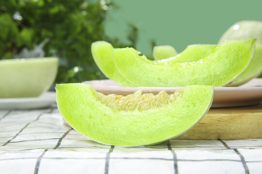 Fresh Honeydew Melon Slices with Green Flesh on Wooden Cutting Board