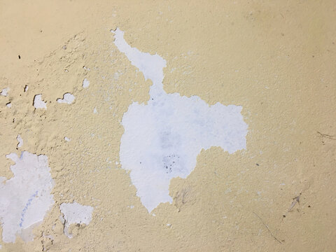 Close up of peeling yellow white wall, cementedand painted wall, aged painted yellow wall, old wall textured background